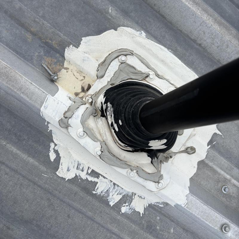 Metal roof pipe boot and sealant on commercial roof