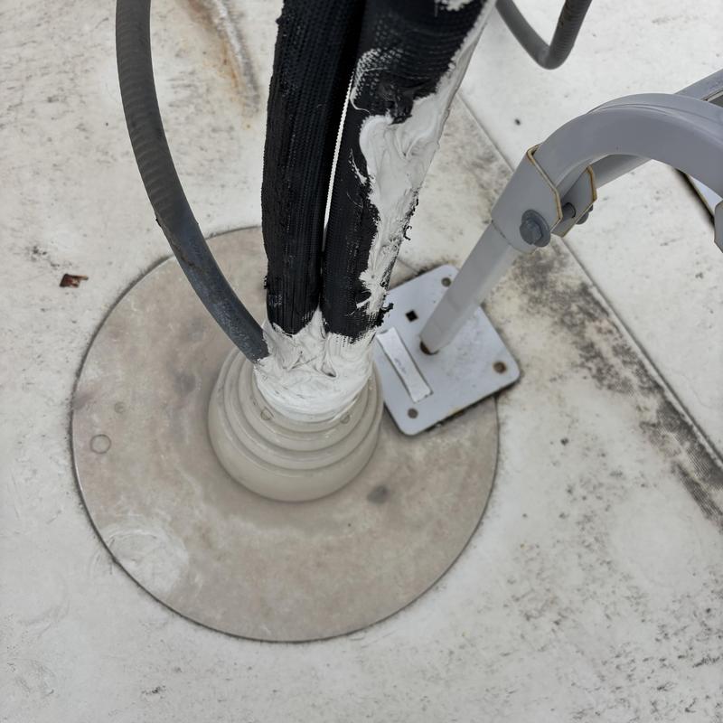 TPO roof cable penetration sealed with flashing and sealant