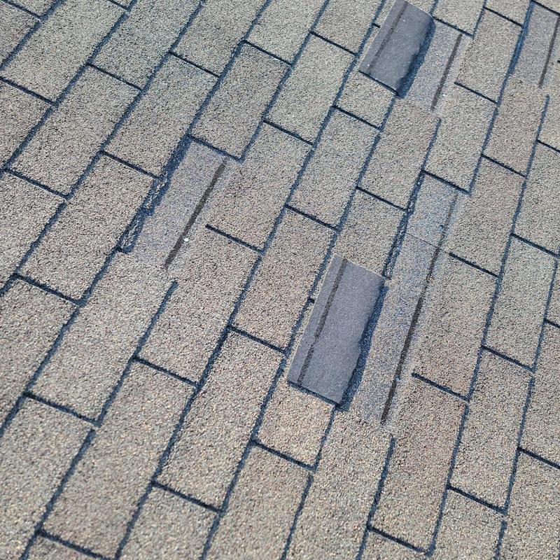 Asphalt roof shingles with isolated wind damage Asphalt roof shingles with isolated wind damage