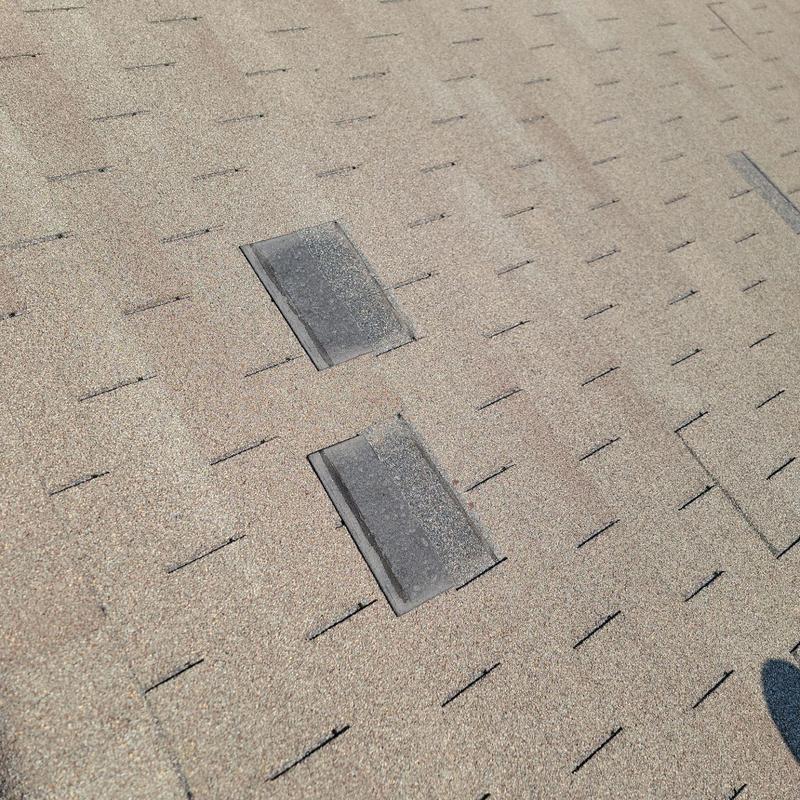 Asphalt roof shingles with isolated wind and hail damage Asphalt roof shingles with isolated wind and hail damage
