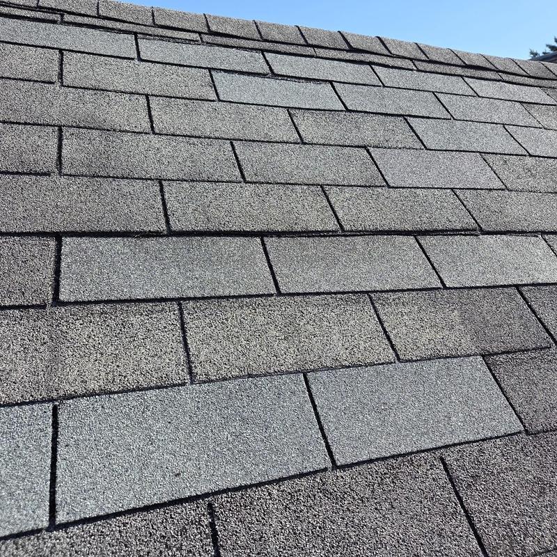 Asphalt shingles on residential roof, new and sealed