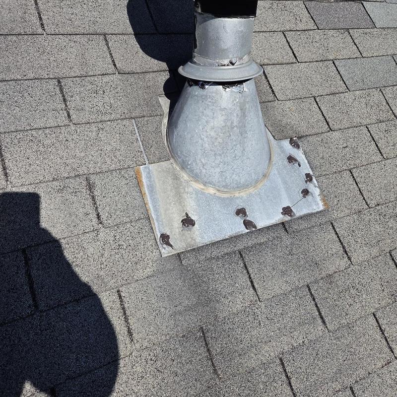 Roof vent flashing with sealant on asphalt shingles