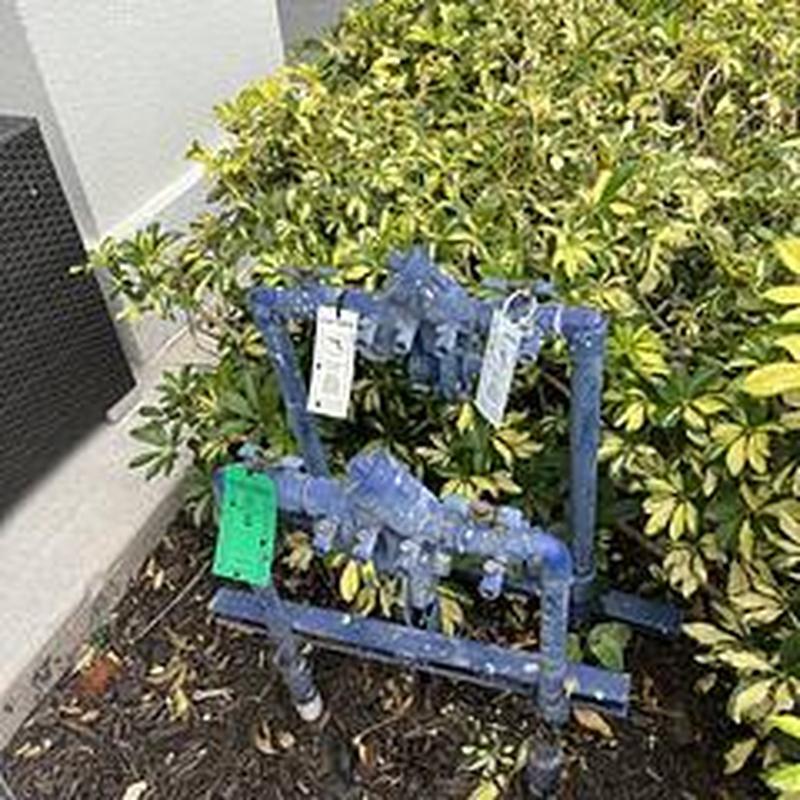 Backflow prevention device with inspection tags outdoors