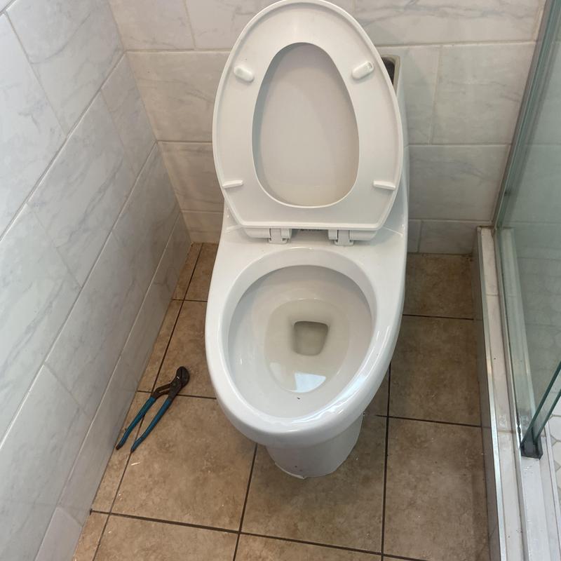 Toilet auger clearing blockage in residential bathroom