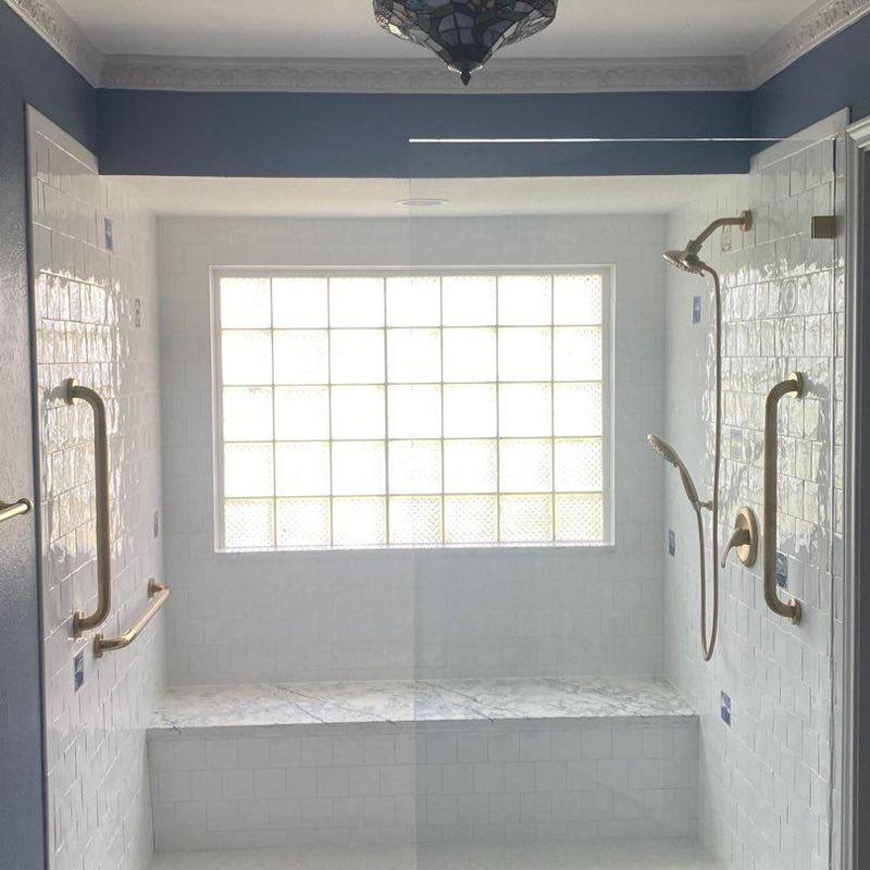 Frameless shower enclosure with brushed brass fixtures Frameless shower enclosure with brushed brass fixtures