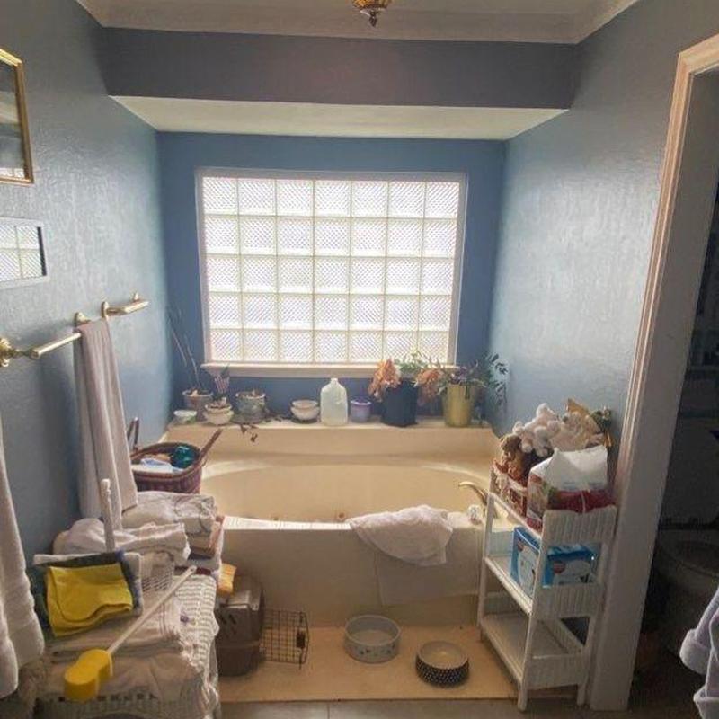 Soaking tub with cluttered bathroom and natural light Soaking tub with cluttered bathroom and natural light