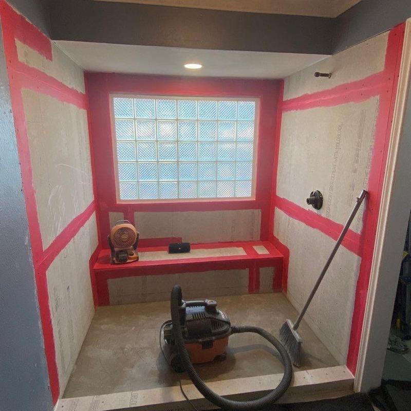Shower waterproofing with red sealing and bench installation Shower waterproofing with red sealing and bench installation