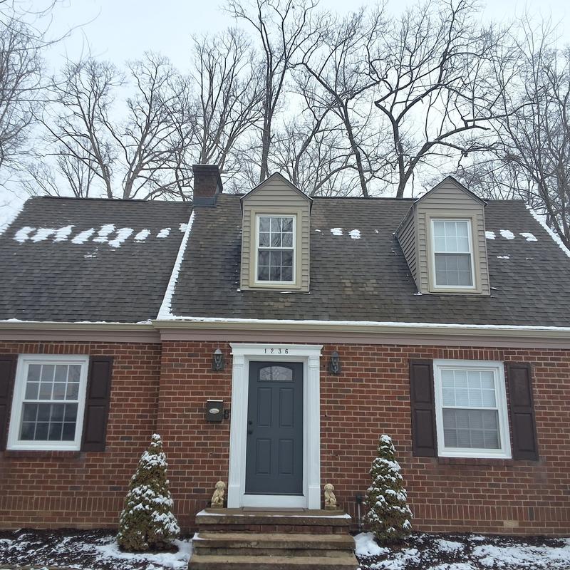 Atlas shingle roof with snow patches on house facade