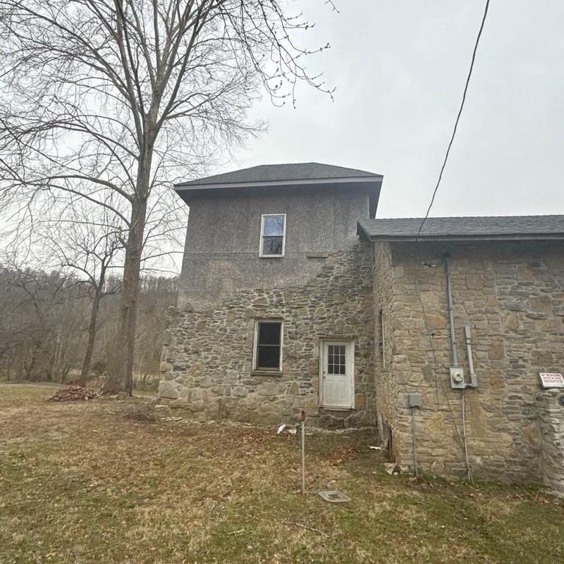 Schoolhouse roof with stone exterior and hail damage