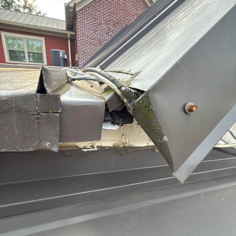 Standing seam metal roof ridge cap and flashing damage