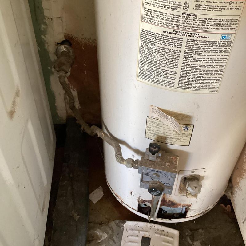 40 gallon gas water heater with old piping in garage