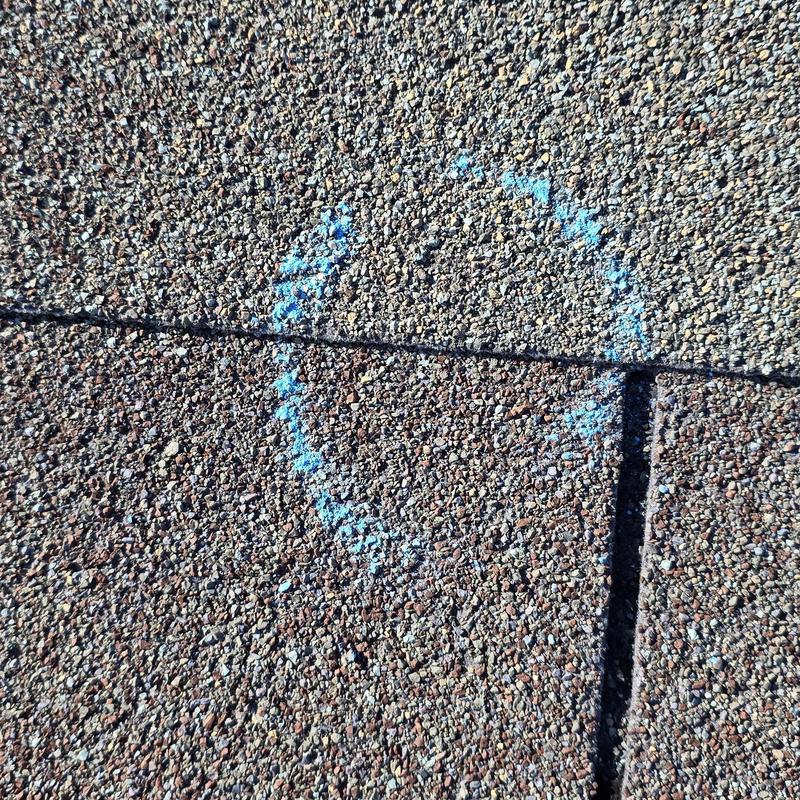 Roof shingles with blue chalk marking on granules