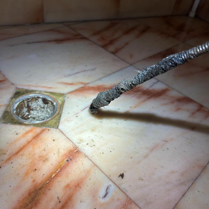 Shower drain clog removal with sewer snake tool