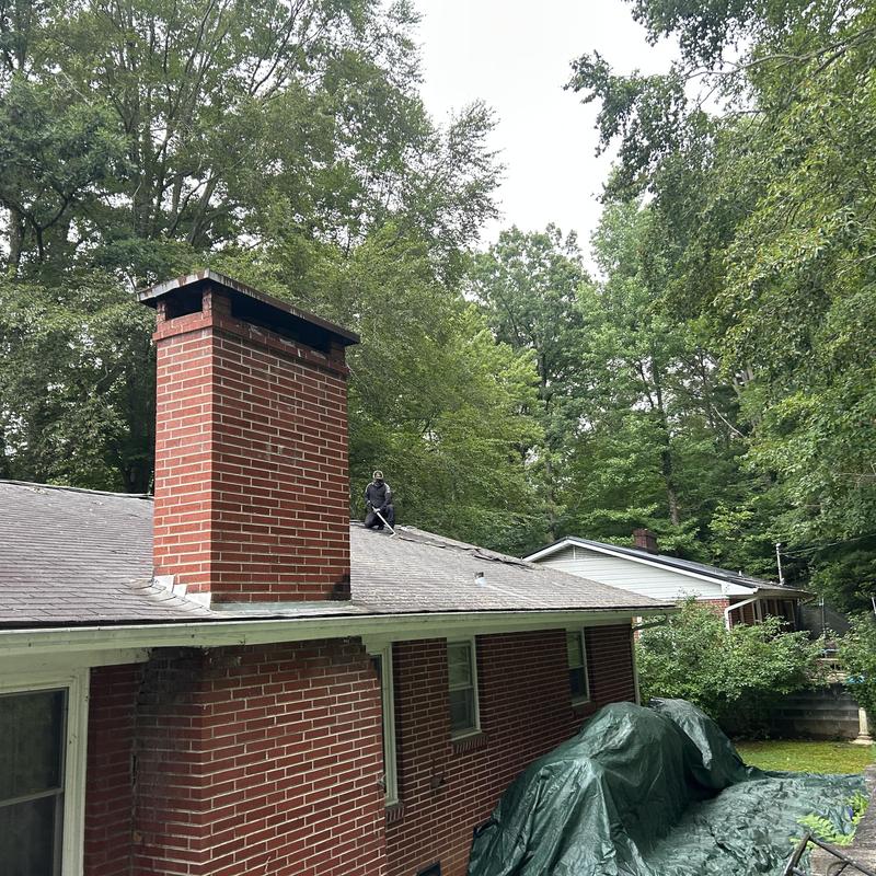Roof shingles replacement with worker on roof
