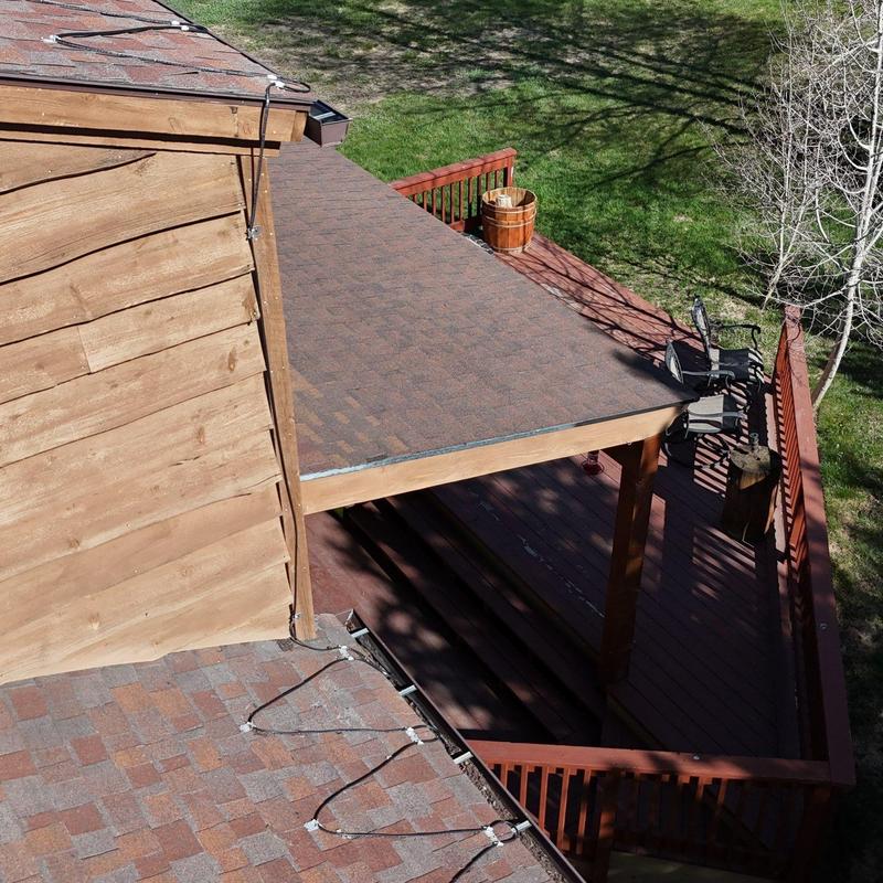 Asphalt shingle roof with heat tape on deck canopy