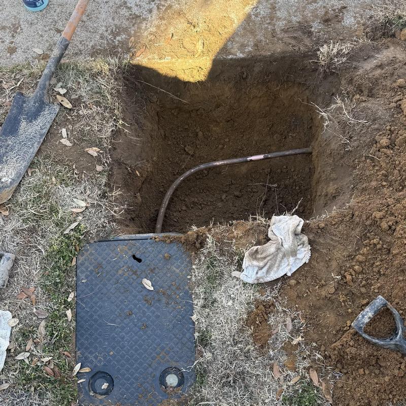 Copper water pipe excavation with tools and cover nearby Copper water pipe excavation with tools and cover nearby
