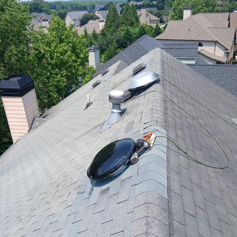 Power vent and damaged roof shingles on residential roof