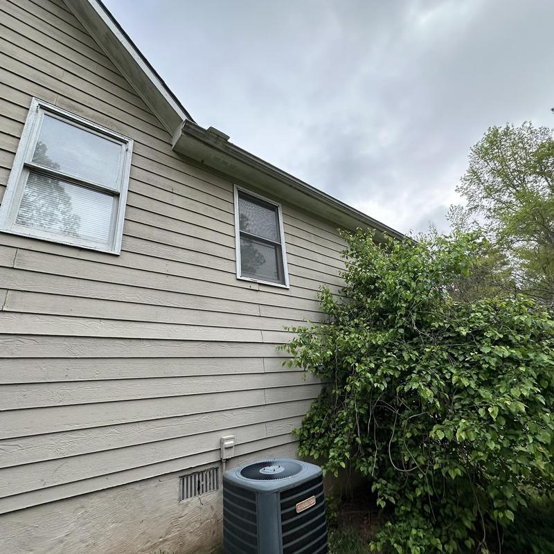Gutter and downspout system rust damage on house exterior