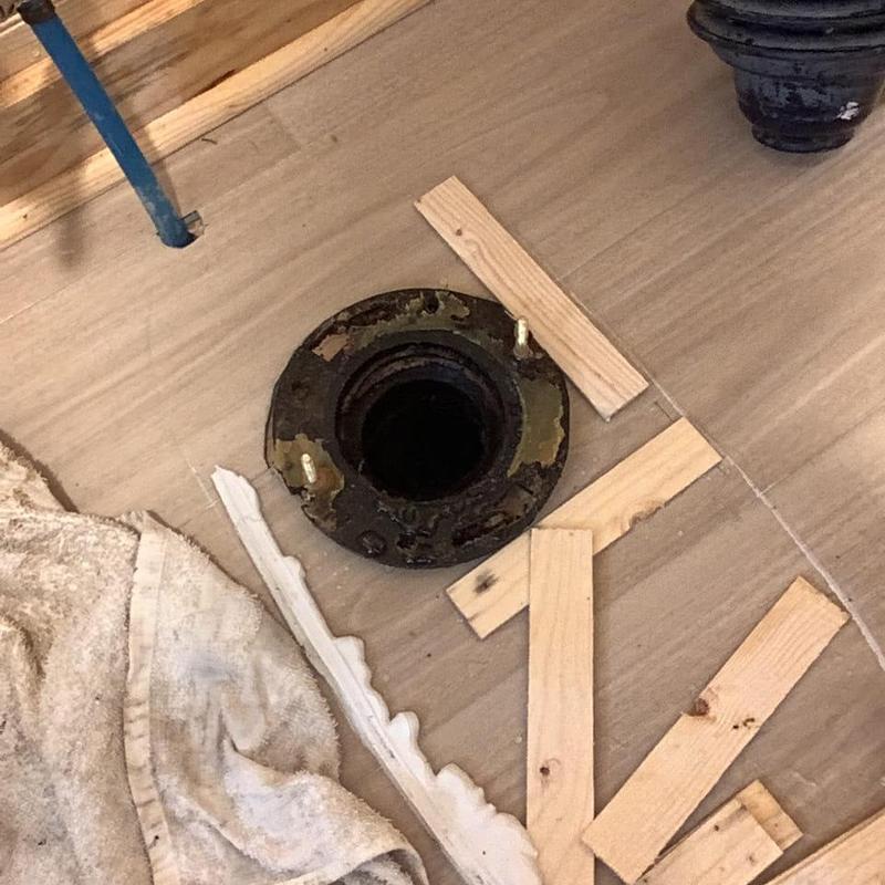 Toilet flange and drain line with floor tiles removed
