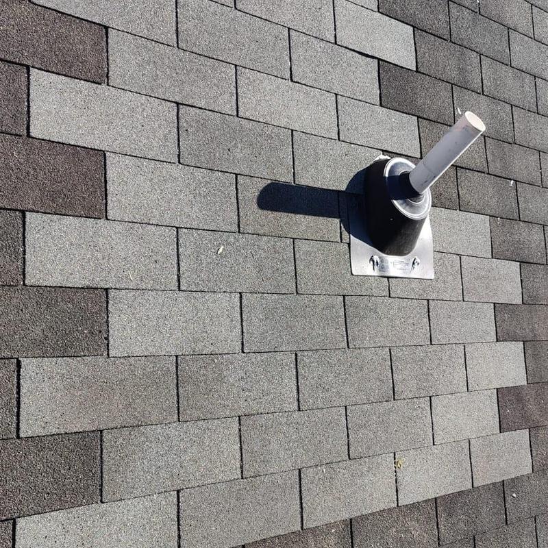Pipe boot on gray asphalt shingle roof with flashing