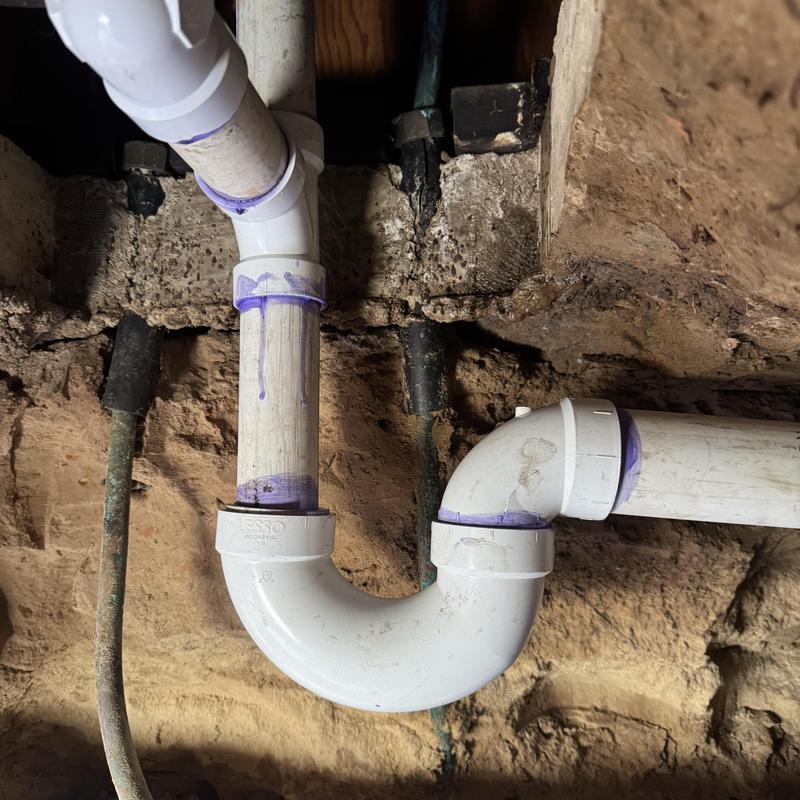 PVC drain pipe replacement with purple primer connections