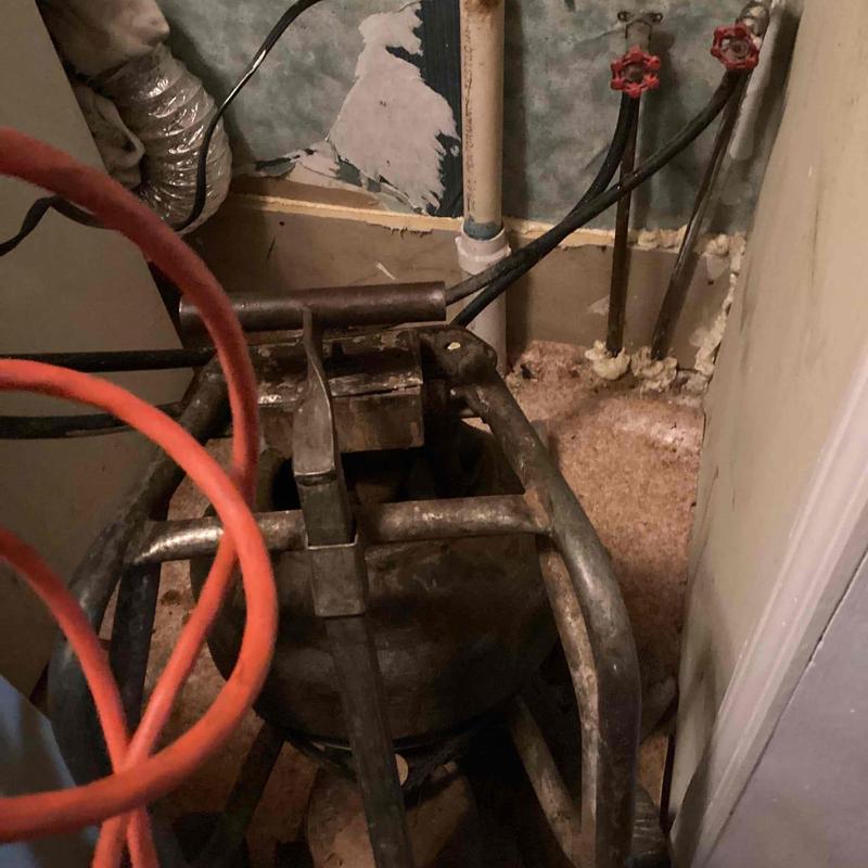 Laundry drain line with cable machine in basement