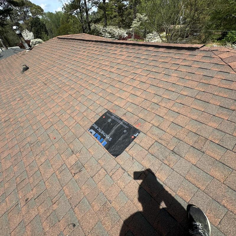 Roof shingles with tarped leak area and nail pop