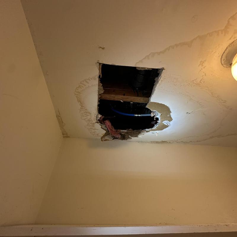 Toilet water line with ceiling water damage and hole