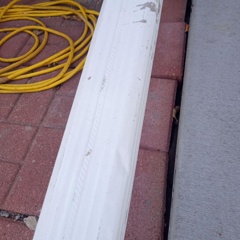 Downspout with dent damage near patio and extension cord Downspout with dent damage near patio and extension cord