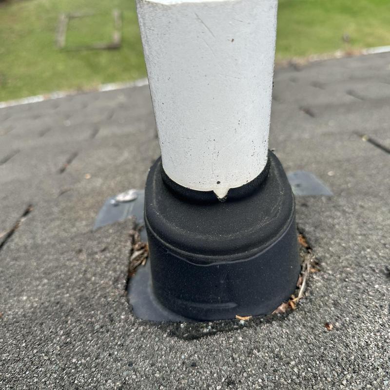Pipe boot with damaged seal on roof shingles