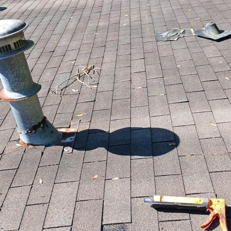 Pipe boots on shingle roof with sealant gun nearby