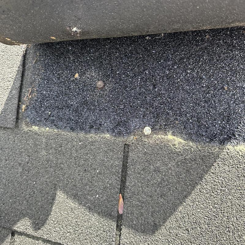 Roof shingles with visible nail pop and discoloration