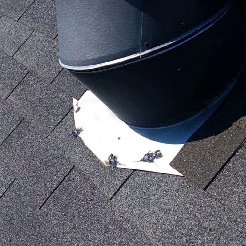 Roof vent flashing with new shingles and caulking