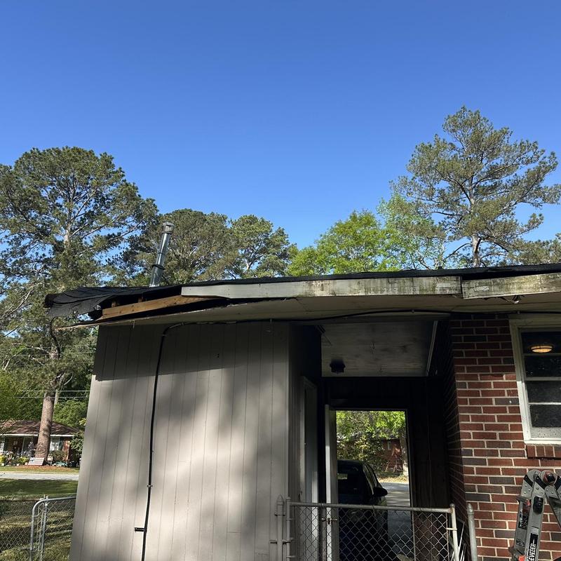 Roof decking and wooden soffit damaged by tree limb strike