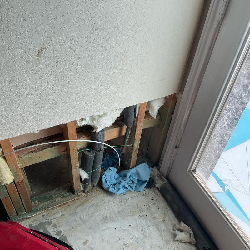 Hot water line rerouted overhead near door frame