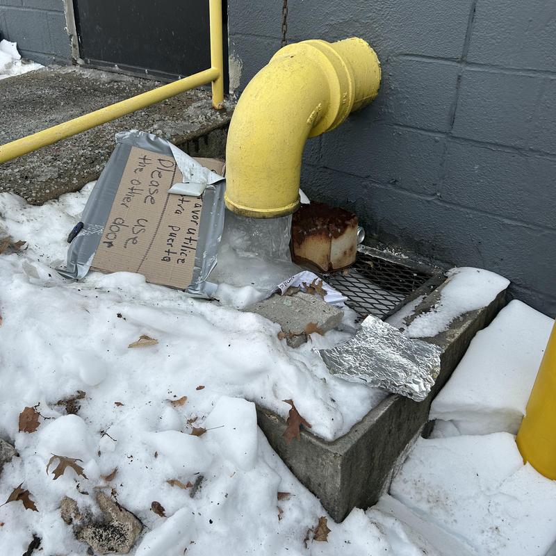 Roof drain pipe with ice blockage outside warehouse