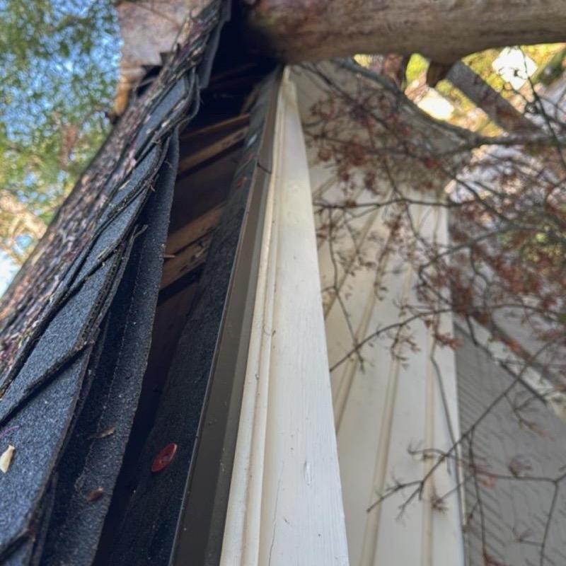 Roof edge fascia and damaged shingles at house corner