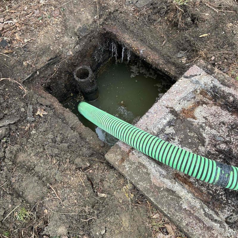 Septic tank with green hose pumping liquid out