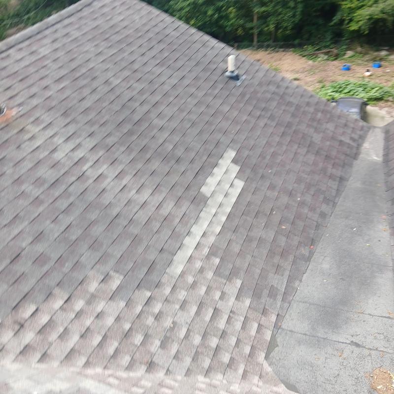Asphalt shingles section with replaced patches on roof