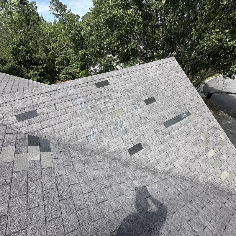 Roof shingles with replaced patches on a residential roof