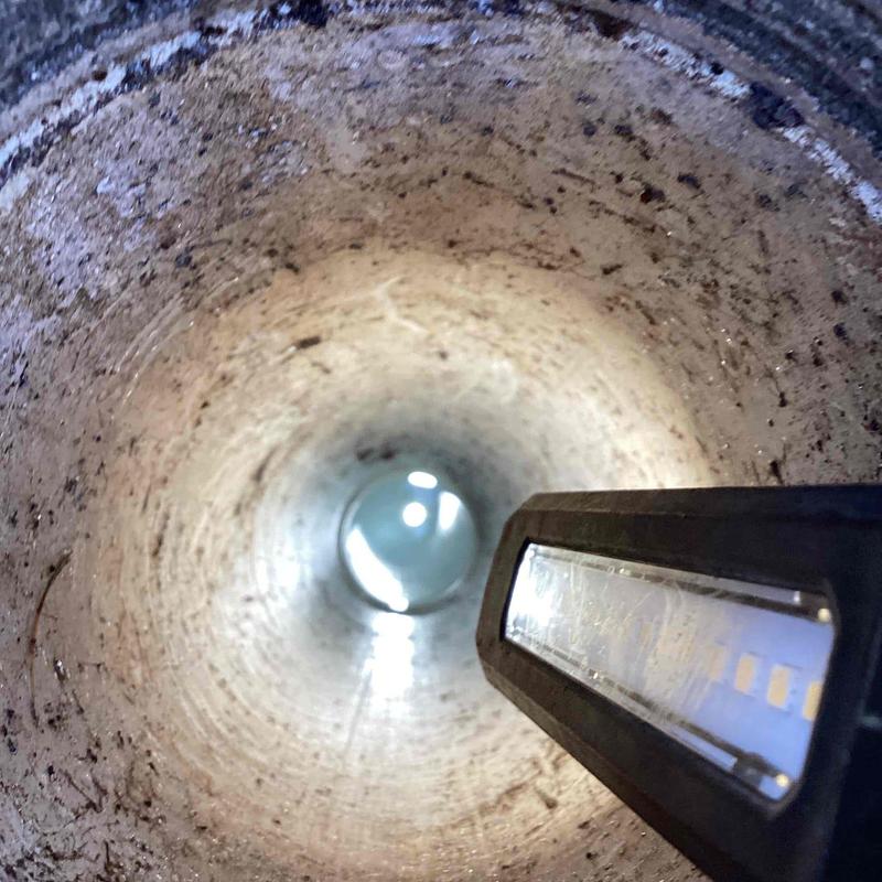 Main sewer line interior with inspection light shining