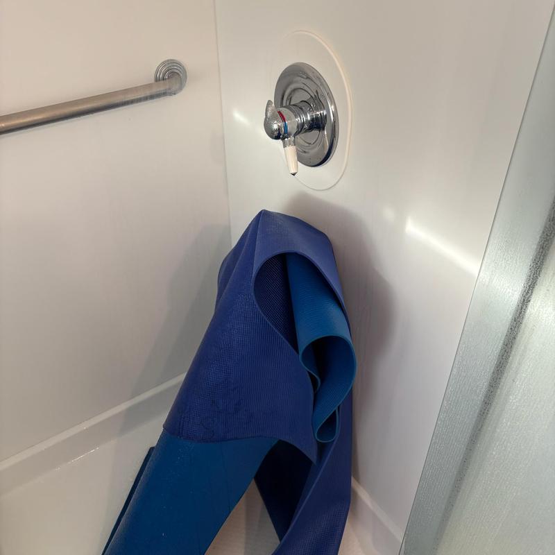 Delta shower valve with blue mat in tub corner
