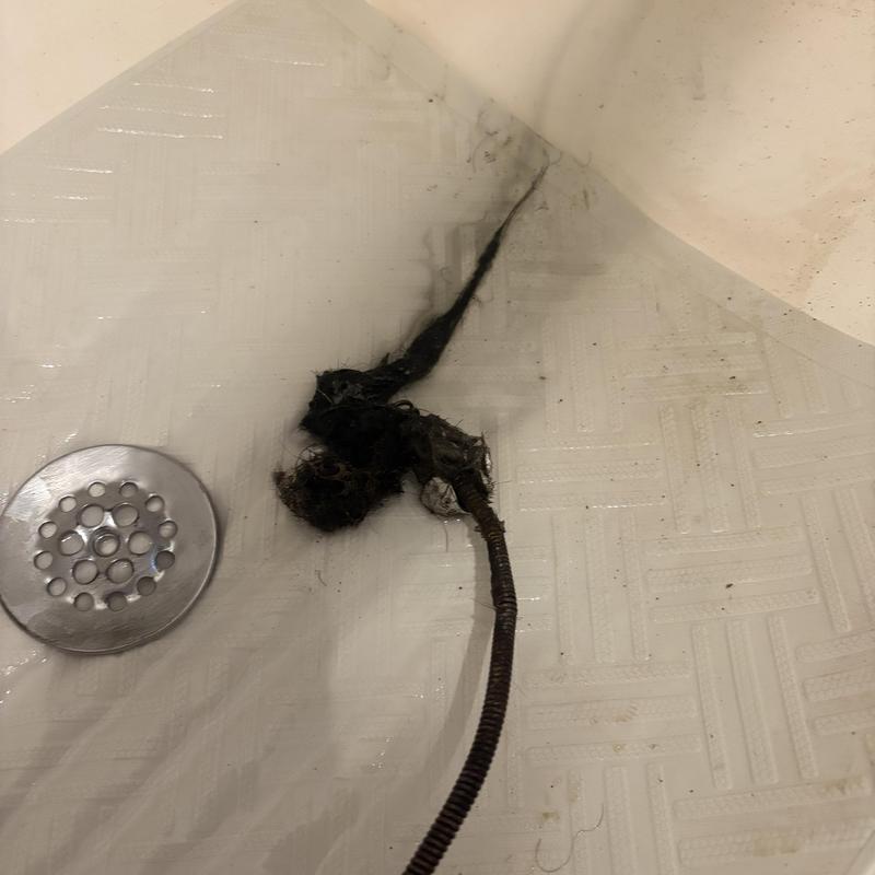 Bathtub drain clog with removed hair blockage and snake cable
