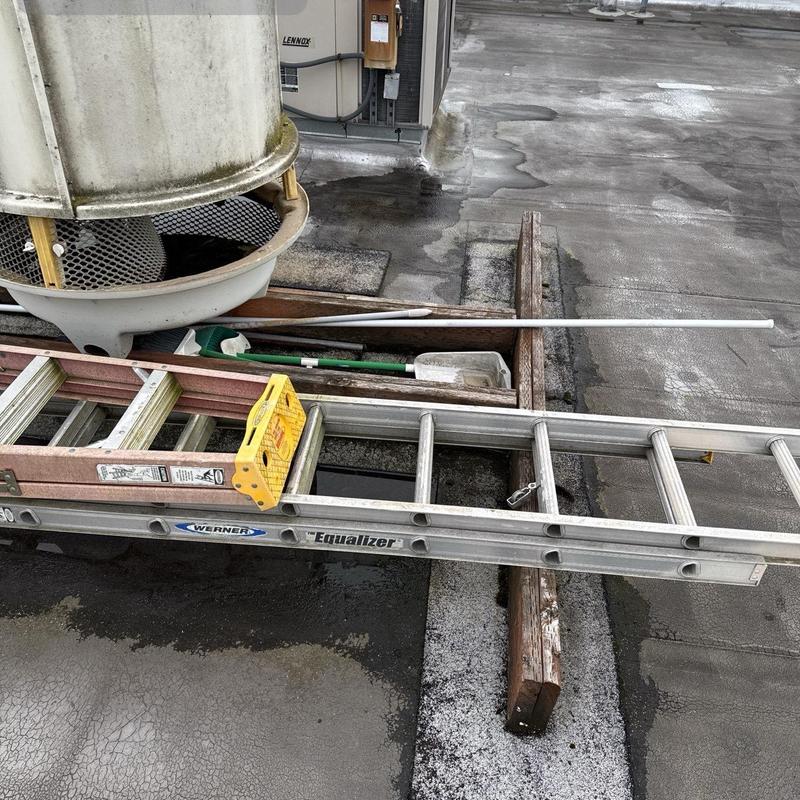 Roof inspection tools and ladder on flat roof