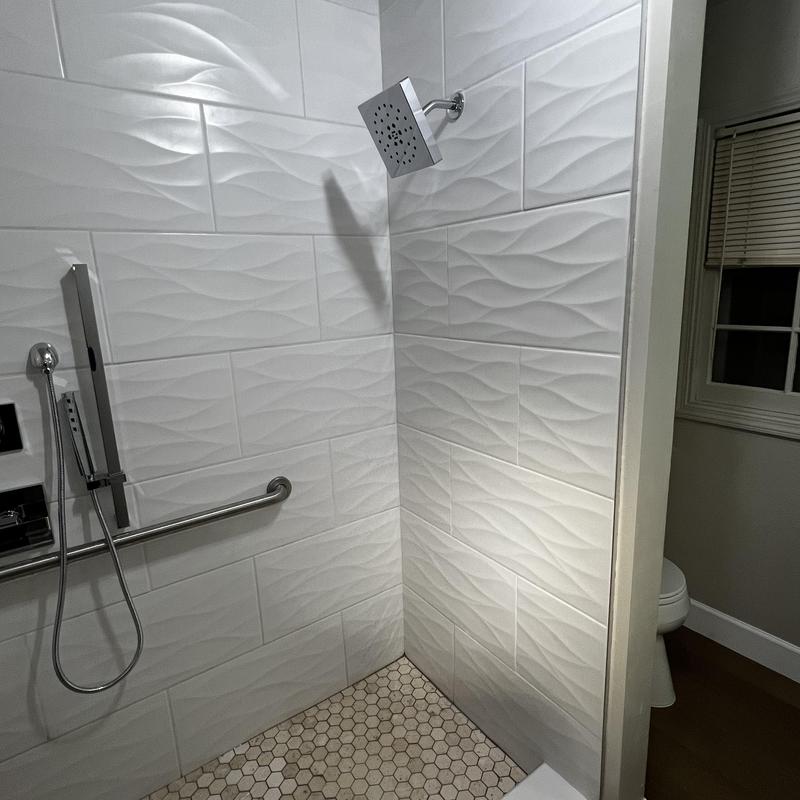 Shower tile and handicap seat installation in bathroom remodel