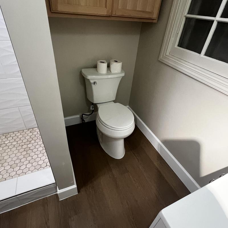 Toilet installation with new flooring and baseboards