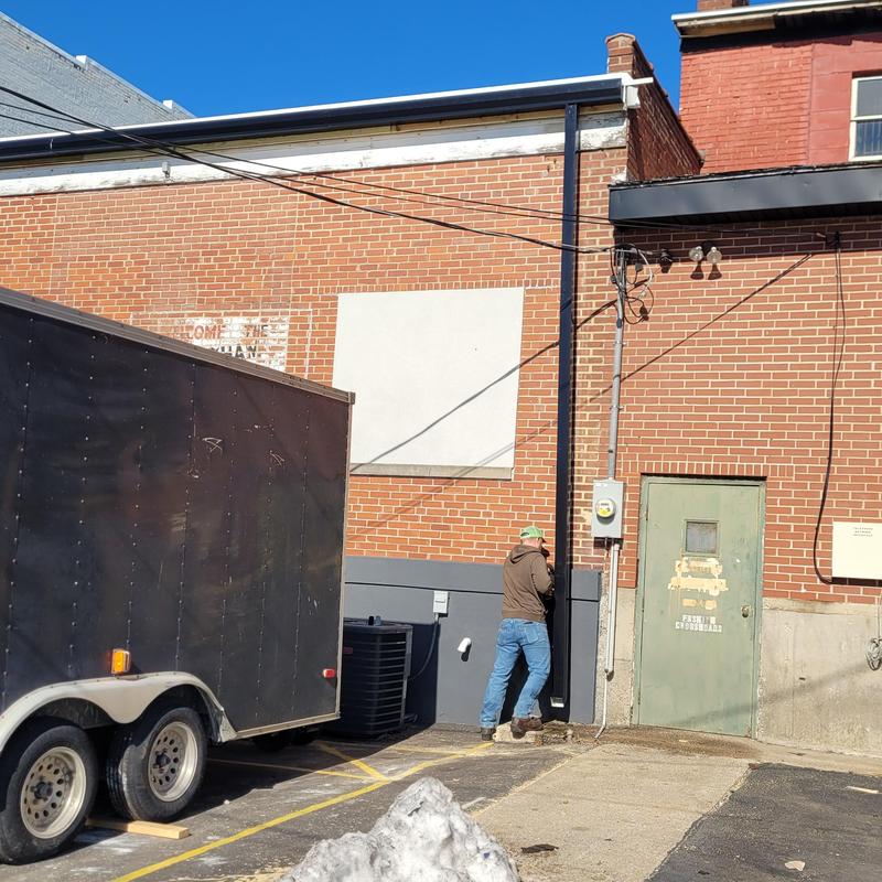 Downspout replacement on flat commercial roof exterior