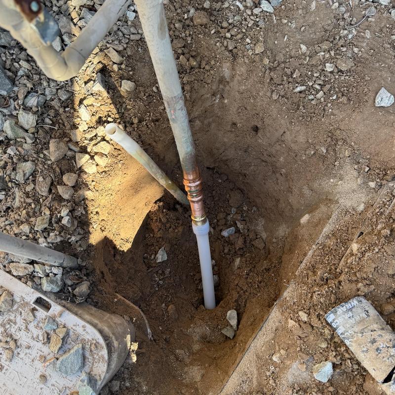1-inch PEX water main service installation in dirt hole