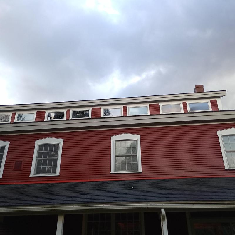 Asphalt shingle roof on red colonial-style home