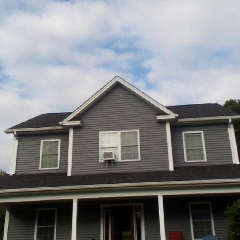 Asphalt shingle roof on two-story gray house